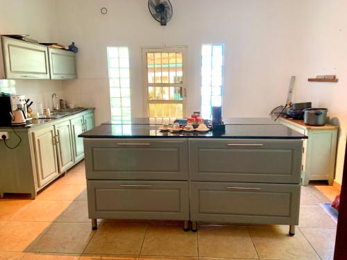 a kitchen with an island in the middle of it at Hibiscus WhiteHouse in Brufut