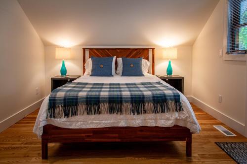 a bedroom with a bed with blue pillows at The Cottage at Forest Inn in Douglas