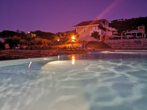 a swimming pool at night with a house in the background at Castellabate House in Santa Maria di Castellabate