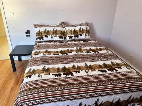 a bed with a blanket with animals on it at Amazing three bedrooms Apartment near EWR and NYC in Linden