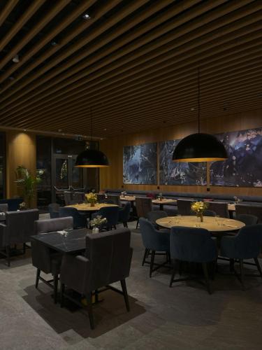 a dining room with tables and chairs and lights at Swissôtel Damian Jasna in Demanovska Dolina