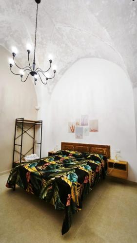 a bedroom with a bed and a chandelier at La Corte nel Vico in Leverano