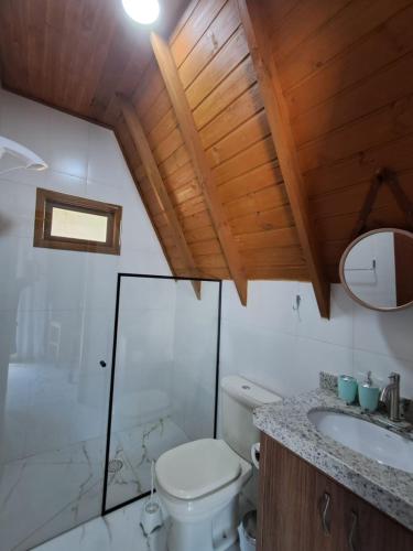 a bathroom with a toilet and a sink and a mirror at Chale Lima - das Colinas in Rio Forcação