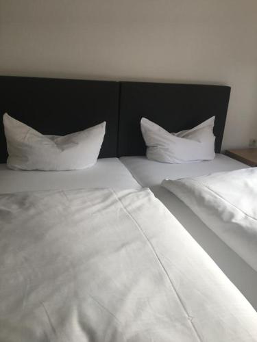 a bed with white sheets and pillows on it at Hotel Relax in Wachenroth