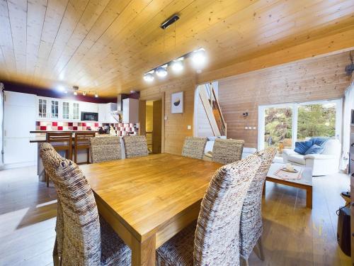 une salle à manger avec une table et des chaises en bois dans l'établissement Chalet La Perle Blanche - Spa, Baby-foot, Terrasse, à Xonrupt-Longemer