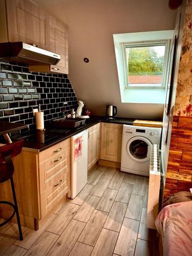 a kitchen with a sink and a washing machine at La Plumeria in Baincthun