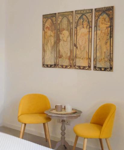two yellow chairs and a table and a picture at Palazzo Fragasso in Rutigliano