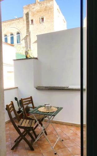 a patio with a table and two chairs on a balcony at Palazzo Fragasso in Rutigliano