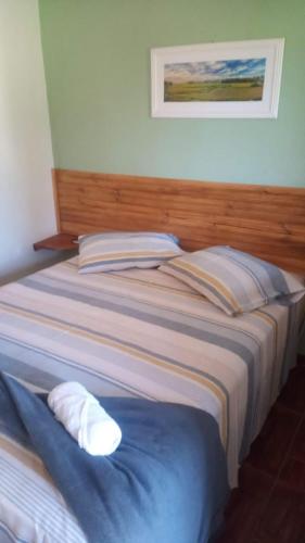 a bed with two pillows on it in a room at Chalés Baruch in Sapucaí-Mirim