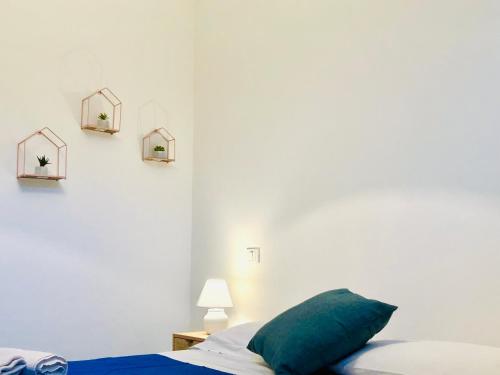 a bedroom with white walls and a bed with a green pillow at Alba Chiara Sperlonga in Sperlonga
