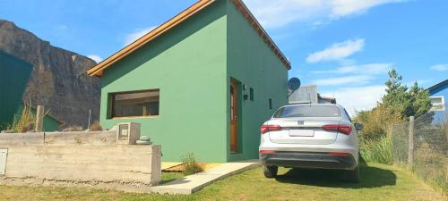 a car parked in front of a green house at La Ribera - Saint Exupéry 90 in El Chalten
