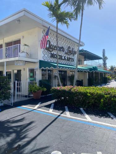 a building with an american flag sign on it at Queens Lodge Motel in West Palm Beach