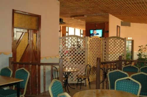 a room with tables and chairs and a television on a balcony at Crystal Hotel in Asmara
