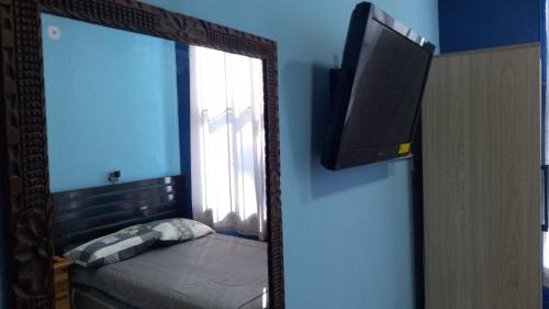 a mirror in a room with a bed and a window at Comfort Home Escalón in San Salvador