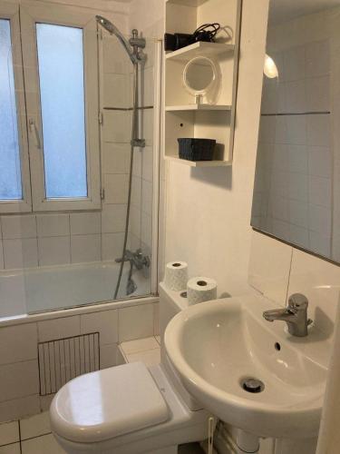 une salle de bain avec un lavabo, des toilettes et une baignoire dans l'établissement IB Saint Martin, à Paris