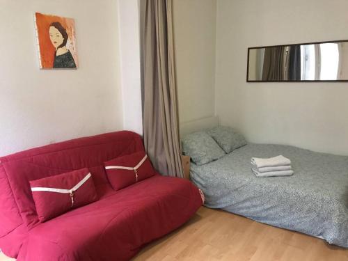 - un salon avec un canapé rouge et un lit dans l'établissement IB Saint Martin, à Paris