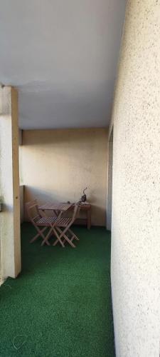 Cette chambre comprend 2 chaises, une table et un sol vert. dans l'établissement Résidence la Croisette Arcachon, à Arcachon