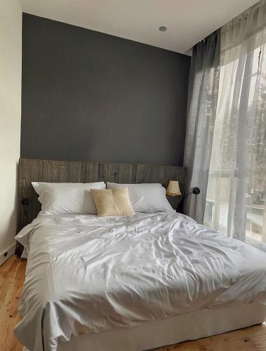 a bedroom with a white bed with a large window at Comfortable Zone in Klong Toi