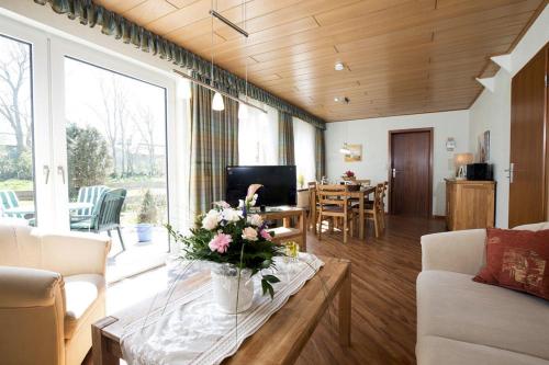 a living room with a table with flowers on it at Kastanie in Fehmarn