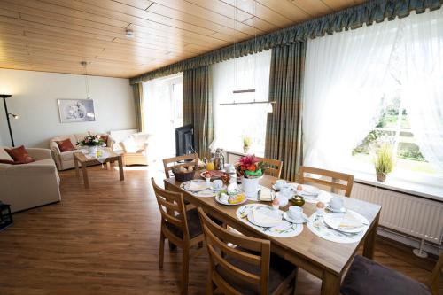 a dining room with a table and chairs and a living room at Kastanie in Fehmarn