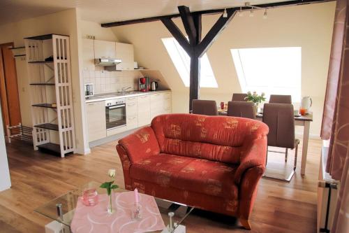 ein Wohnzimmer mit einem roten Stuhl und einem Tisch in der Unterkunft Rose in Fehmarn