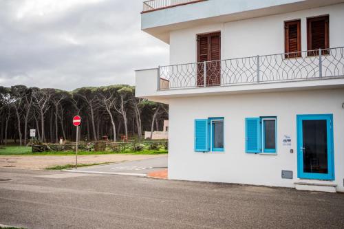 a white building with blue windows and a stop sign at Grazioso Bilocale fronte mare in Santa Lucia