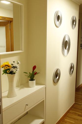 a bathroom with a mirror and a vase with flowers at Pensión A Solaina in O Pedrouzo