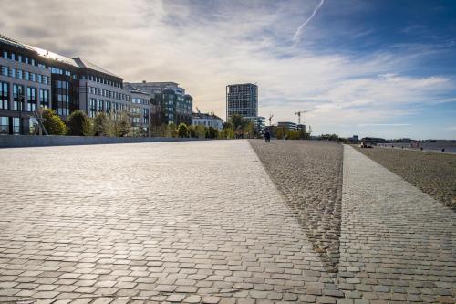 a cobblestone street in a city with tall buildings at Apartment Close to Zuid Park in Antwerp