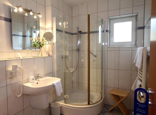 a bathroom with a shower and a sink and a tub at Hotel Lindemann in Bad Nauheim