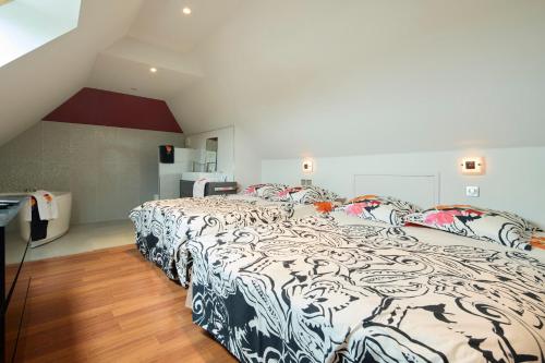 een slaapkamer met een bed met een zwart-wit dekbed bij Rivoli in Pornichet