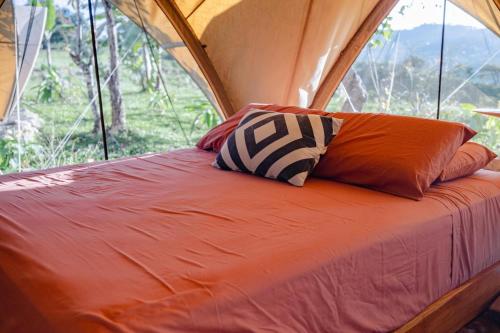 a bed in a tent with two pillows on it at Eco Luxe Glamping Nest #5 - 2 Queen Beds at Holos in Barú