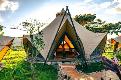 a tent in the middle of a field at Eco Luxe Glamping Nest #2 - 2 Queen Beds at Holos in Barú