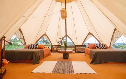 a tent with two beds and a table in a room at Eco Luxe Glamping Nest #2 - 2 Queen Beds at Holos in Barú