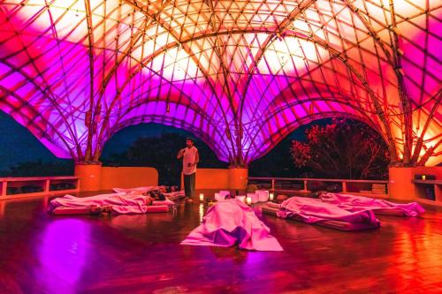 a man standing in a building with purple lights at Eco Luxe Glamping Nest #2 - 2 Queen Beds at Holos in Barú