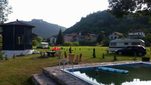 a backyard with a swimming pool and a tent and a car at Auto Kamp Lav in Kulen Vakuf