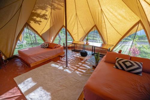 a tent with two beds and a table in it at Eco Luxe Glamping Nest #4 - 2 Queen Beds at Holos in Barú