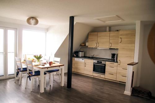 a kitchen and dining room with a table and chairs at Gänseblümchen in Fehmarn