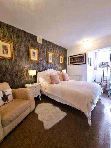 a bedroom with a large white bed and a couch at Station Cottage Hawes in Hawes