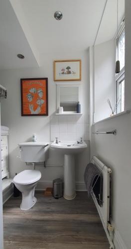a white bathroom with a sink and a toilet at Station Cottage Hawes in Hawes