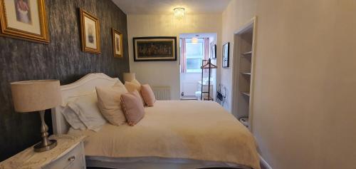 a bedroom with a bed with white sheets and pillows at Station Cottage Hawes in Hawes