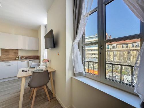 Il comprend une cuisine avec un bureau et une grande fenêtre. dans l'établissement Studio Chaleureux et Lumineux - Centre Clermont Blatin B, à Clermont-Ferrand