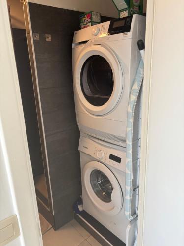 a washing machine and a washer in a closet at Bright studio close to everything! in Brussels
