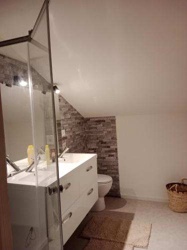 une salle de bain avec un lavabo et une douche en verre dans l'établissement La tanière de Lise, à Puyravault