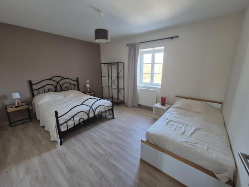una camera da letto con due letti e una finestra di Hébergement Cressia a Cressia