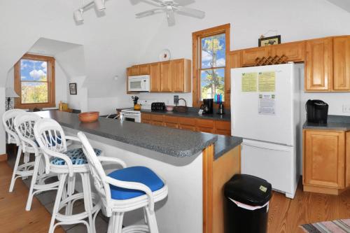 a kitchen with white appliances and wooden cabinets at Heron's Cove on Salt Meadow - Pet friendly, waterfront home! in Deep Hole