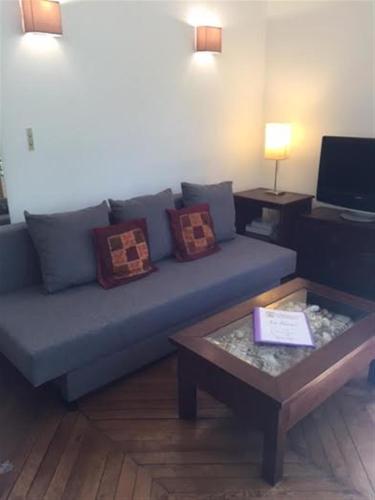 un salon avec un canapé bleu et une table dans l'établissement Le Alesia, à Paris