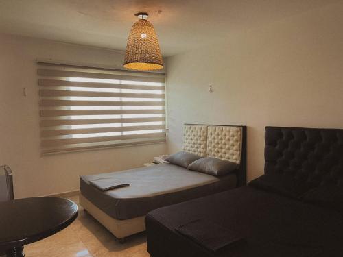 a living room with a couch and a table and a bed at Surfer Grill, alojamiento en puerto Colombia, pradormar, Habitación Suite in Pradomar