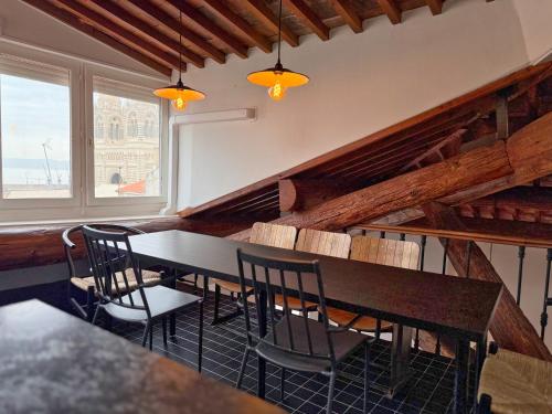 une salle à manger avec une table et des chaises et une fenêtre dans l'établissement Duplex avec Vue Exceptionnelle - Calme & Confort, à Marseille