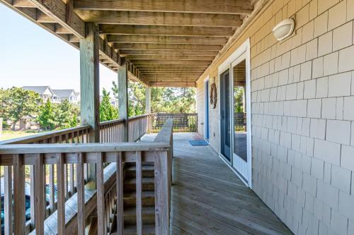 a porch of a house with a wooden deck at Shore Enough in Sanderling