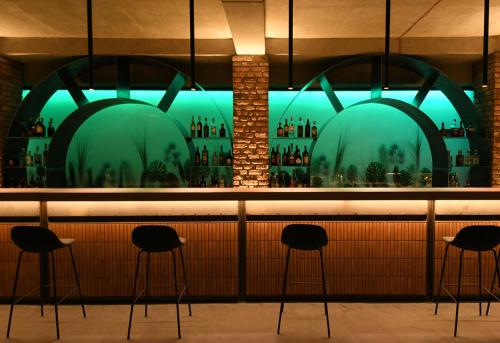 a bar with black stools in front of a window at Dilijani Tun Hotel & Restaurant in Dilijan